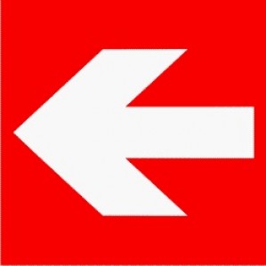 A bold white left-pointing EM85 Signs of Safety Emergency directional arrow sign centered on a bright red background.