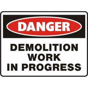 A rectangular sign with a bold red oval at the top labeled "danger" and text below stating "demolition work in progress" on a white background with a black border, designed to warn of signsofsafety.
